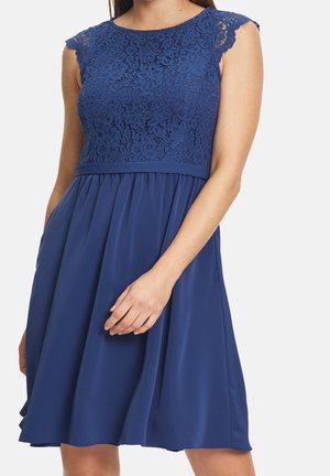 Marineblauwe jurk met kanten lijfje, kapmouwtjes en een vloeiende rok. Heeft een nauwsluitende taille en zijzakken. Gladde textuur overal.