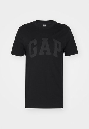 Črna bombažna majica s kratkimi rokavi, ki ima na sprednji strani mat črn logotip "GAP". Ohlapen kroj in okrogla izrezana vrata.