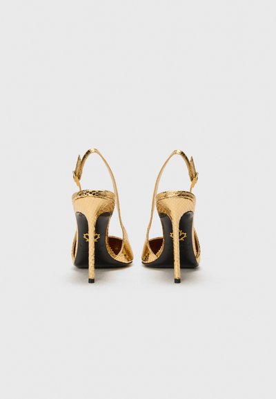 Zapatos de tacón alto de charol dorado con un patrón texturizado, diseño slingback y interior negro con un logo.
