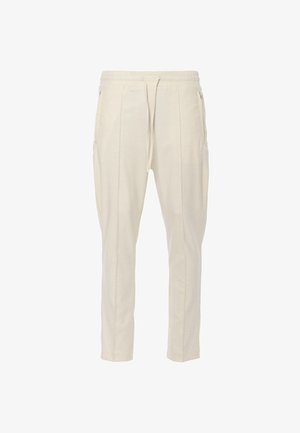 Beige taps toelopende broek met elastische tailleband en trekkoord, voorzien van zijzakken en subtiele plooien voor extra designdetails.