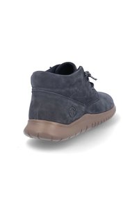 Botín de ante azul marino oscuro con puntera redondeada, superficie texturizada, cordones moteados en negro y blanco, y suela de goma marrón clara.