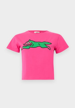 Top court à manches courtes rose vif avec un chien en course de style dessin animé vert aux dents pointues imprimé sur la poitrine.