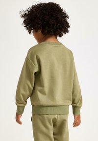 Felpa verde oliva con scollo rotondo, polsini e bordo a coste. Realizzata in tessuto morbido, presenta una vestibilità comoda, adatta per l'abbigliamento casual.