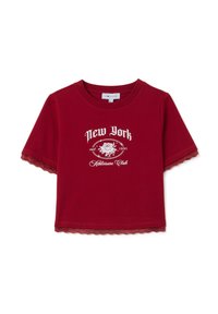 Camiseta corta roja con texto blanco "New York Athleisure Club est. 1991" y gráfico de rosas, con encaje en las mangas y el dobladillo.