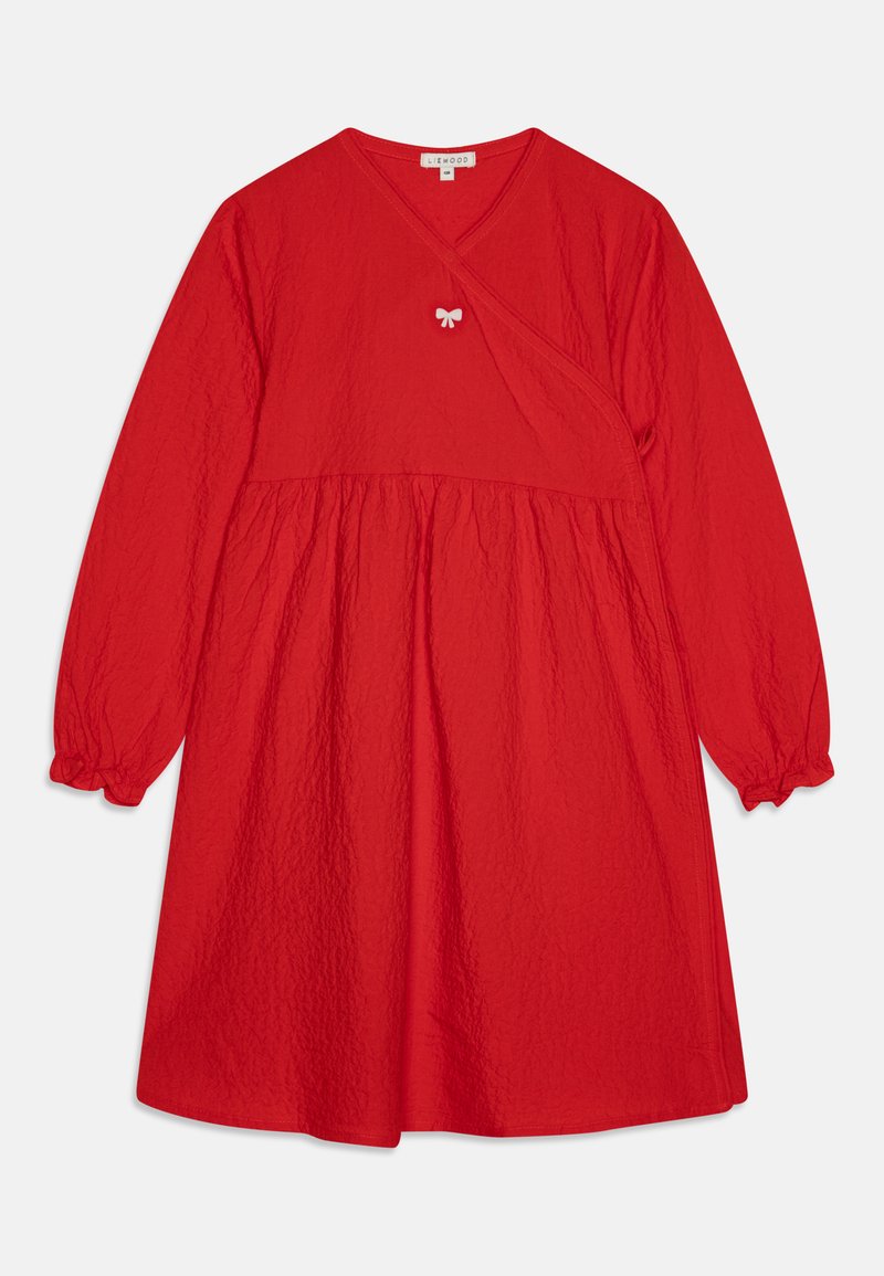 Raudona suknelė su ilgomis sutrauktomis rankovėmis, pagaminta iš tekstūruoto audinio su mažyčiu kaspinu krūtinės srityje. A-formos siluetas.