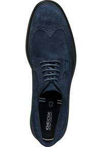 Zapato de vestir de ante azul marino con detalles de ala, punta redonda y diseño de cordones. Presenta la marca Geox en la plantilla.
