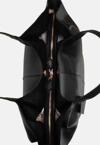Borsa tote nera in pelle con superficie testurizzata, zip dorata e due tasche esterne. L'interno è foderato con un tessuto chiaro.