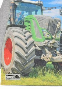 Grüner Traktor mit großen, strukturierten Reifen und roten Akzenten. Verfügt über einen stabilen Körper, auffällige Scheinwerfer und einen klaren Himmel im Hintergrund.