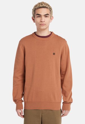 Maglione di colore ruggine realizzato in tessuto morbido, con scollo rotondo, maniche lunghe e polsini e orlo a costine. Piccolo logo sul petto.