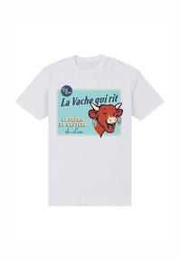 Vit bomullströja med en retrodesign som visar en leende ko, text i blått och gult, samt en blå rutnätsbakgrund.