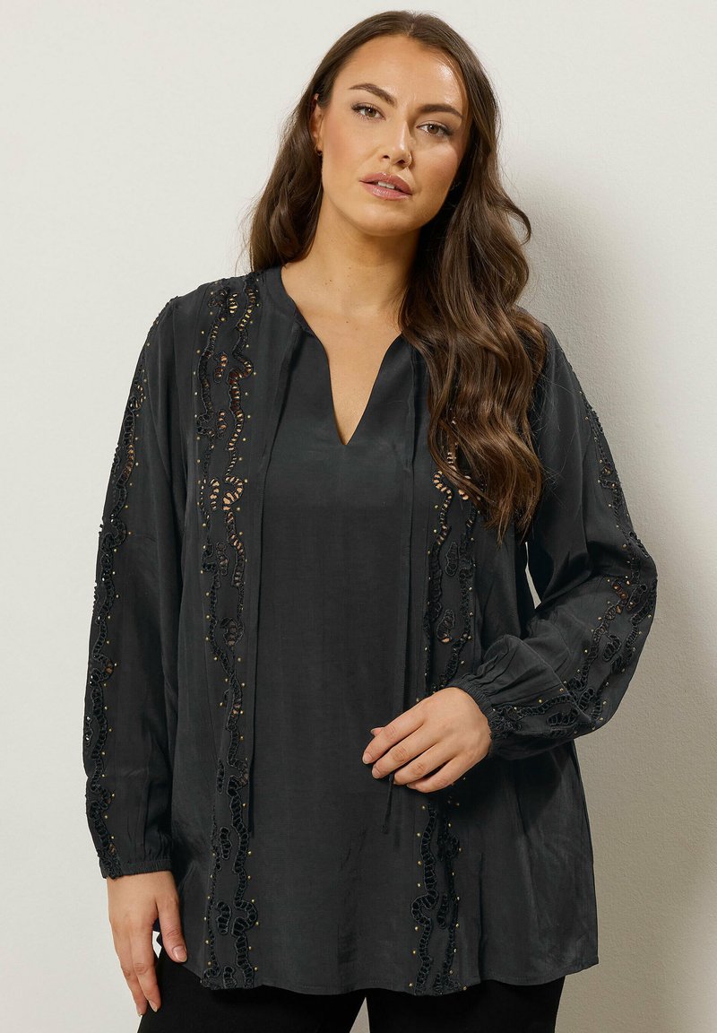Sort bluse med lange ærmer, V-udskæring, detaljeret blonde med broderi og afslappet pasform. Blød, glat stofkvalitet.