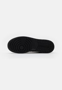 Fekete sneaker talp textúrált mintákkal és kör alakú design-nal. Az oldalán Nike logóval és gumi grip felülettel rendelkezik.