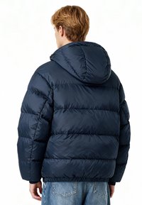 Veste matelassée bleue marine avec capuche, présentant des sections matelassées et un ourlet élastique. Matière lisse et brillante avec une coupe décontractée. Coutures visibles.