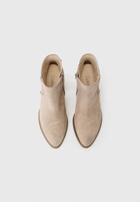 Beige ankelstøvler laget av semsket skinn, med spiss tå, sidelukking og minimalisk design. Teksturert overdel med glatt såle.