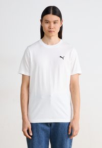 Hvit bomulls T-skjorte med korte ermer, rund halsutskjæring og en liten svart Puma-logo på venstre bryst. Enkelt og ukomplisert design.