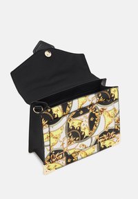 Sac à main noir avec rabat ouvert, motif baroque doré et jaune sur le devant, protège-angles dorés et intérieur noir visible.