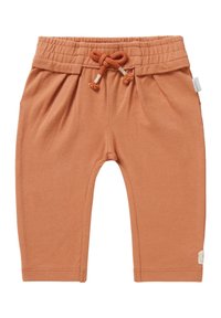 Rude bawełniane spodnie w kolorze rdzawym z elastycznym paskiem w talii, regulowanym sznurkiem oraz bocznymi pliskami. Posiadają małą metkę na lewym dolnym brzegu.