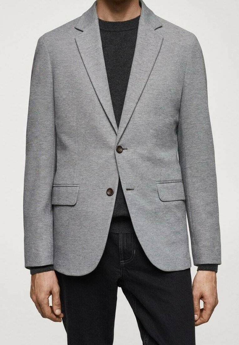 Blazer grigio chiaro realizzato in tessuto testurizzato, con chiusura a due bottoni, rever a punta e due tasche frontali, abbinato a una parte superiore scura.