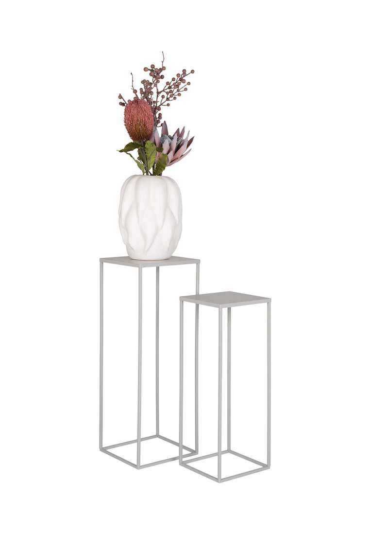 Weißer texturierter Vase mit rosa und lila Blumen auf zwei geschachtelten minimalistischen Metallpflanzenständern mit dünnen Beinen.