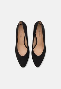 Black suede pumps with a pointed toe and an elegant silhouette. The interior features a light-colored lining, enhancing its sleek design.