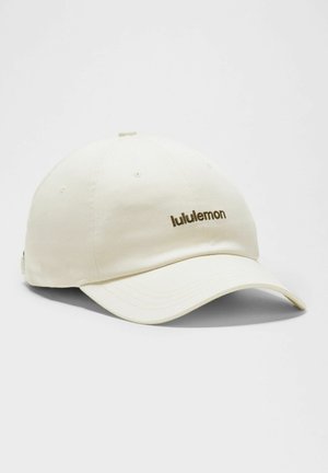 Off-white baseballkasket med buet skygge, der har en lille "lululemon"-logo broderet i brunt på frontpanelet.