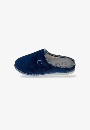 Pantofola slip-on blu navy con la lettera "C" ricamata in azzurro, foderata in materiale morbido e con un bordo decorativo cucito lungo i lati, vista di lato.