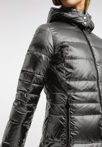 Czarna kurtka puchowa z błyszczącym wykończeniem, z poziomymi pikowanymi sekcjami, suwakiem z przodu oraz dopasowanym, regulowanym kapturem.