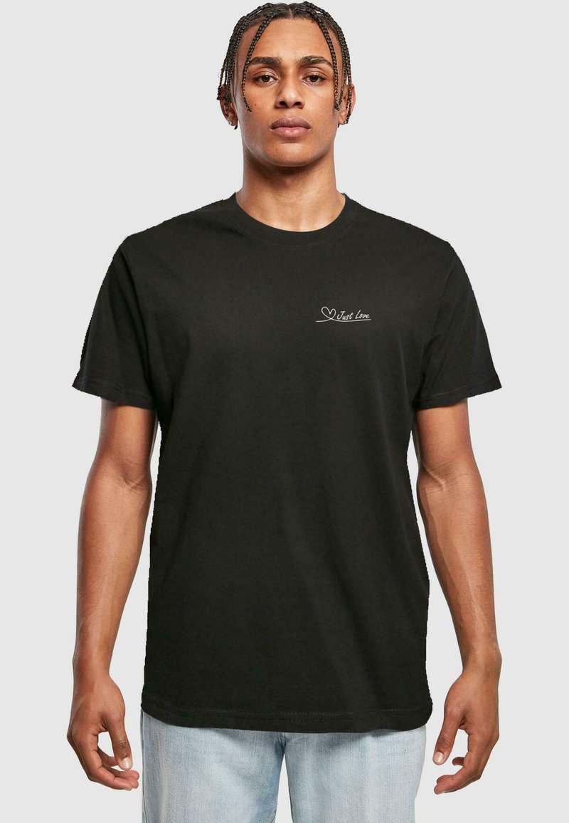 Zwarte katoenen t-shirt met korte mouwen en een ronde hals, met een witte tekst "Just Love" en een hartgrafiek op de borst.