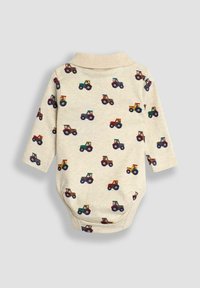 Bodysuit à manches longues en beige clair avec un motif de tracteur répété dans différentes couleurs. Doté d'un col et en matériau coton doux.