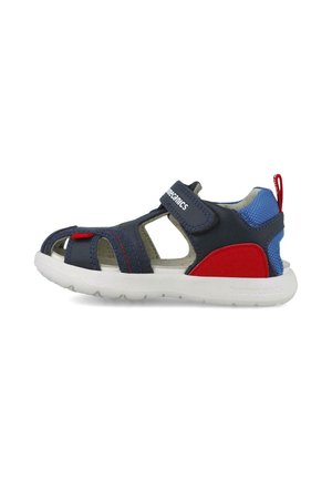 Sandalia infantil en azul y rojo con lados abiertos, correa de velcro, suela blanca y detalles texturizados en el talón y los paneles laterales.