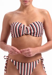 Top bikini a bandeau a righe con dettaglio centrale a fiocco e gancio. Il fondo presenta lacci laterali con nappine multicolori.