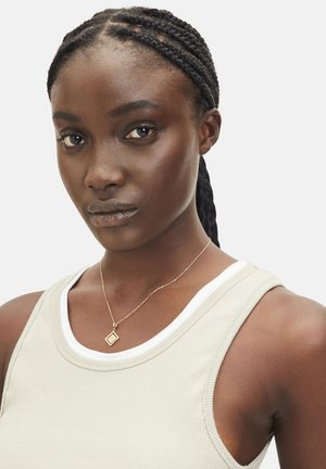 Bruin geribbelde tanktop met witte rand en dunne bandjes, met een delicate gouden ketting met een diamanten hanger.