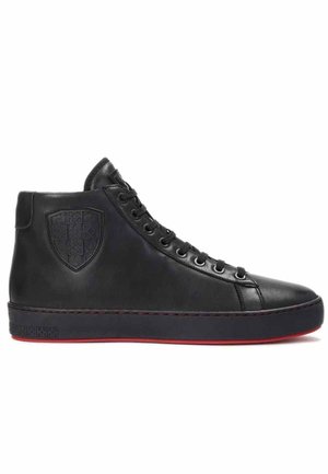 Czarny skórzany sneaker za kostkę z wytłoczonym logo tarczy z boku, czarne sznurówki i czerwony detal na podeszwie, pokazany z profilu na białym tle.