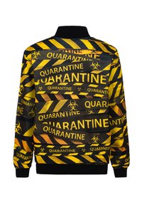 Mustard ja musta bomber-jakk, millel on julge "QUARANTINE" mustriga, biohuvi sümbolid ja triibuline ohutuslint. Tekstureeritud kangas koos soonikute mansettidega.