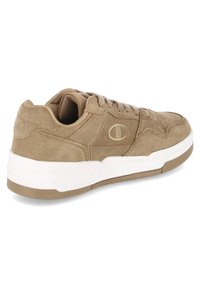 Hellbrauner Wildleder-Sneaker mit abgerundetem Zehenbereich, gepolstertem Schaft und weißer Gummisohle. Verfügt über ein strukturiertes Seitenpaneel und dezentes Logodetail.