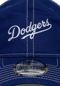 Mėlynas beisbolo kepuraitė su balta siuvinėta „Dodgers“ logo, turinti 9TWENTY reguliuojamą dirželį ir kontrastingas siūles.
