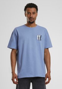 Lyseblå bomull T-skjorte med korte ermer og rund hals. Har en svart grafisk "ff" logo på venstre bryst.