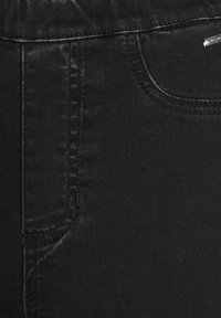 Tissu en denim noir avec une texture lisse, présentant une poche avant et des détails de couture subtils. Style jean classique avec une coupe slim.