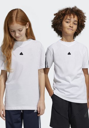 Deux enfants portent des t-shirts en coton blancs. Le t-shirt de la fille a un logo noir ; celui du garçon a des bordures noires aux manches, associé à un short sombre.