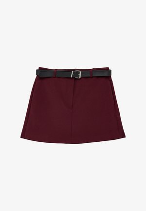 Mørkerød A-formet nederdel med sidelommer og sort bælte med sølvspænde, lagt fladt på hvid baggrund.