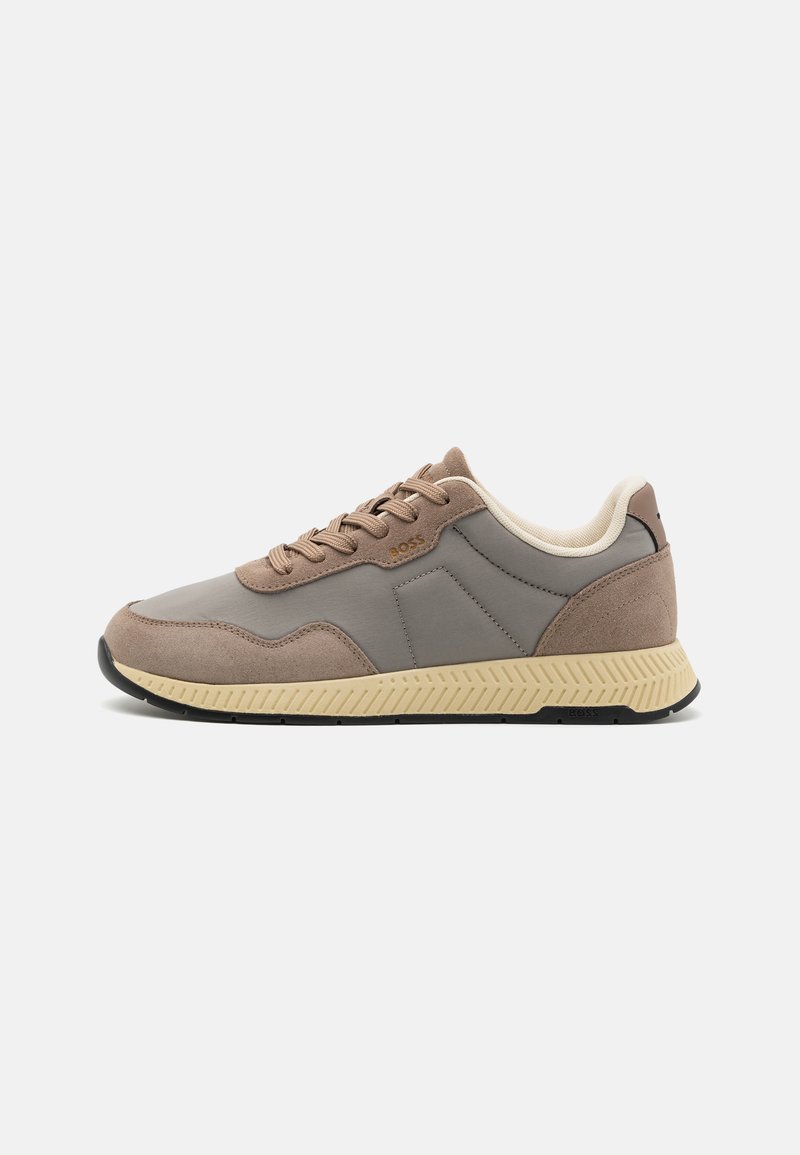 Baskets grises et brunes avec un mélange de cuir lisse et de daim. Présentent une semelle texturée blanc cassé et des lacets assortis. Logo accentué sur le côté.