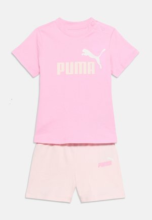 Maglietta a maniche corte rosa chiaro per bambino piccolo con logo Puma bianco e pantaloncini coordinati con logo Puma sulla gamba sinistra.