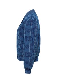 Kurtka bomberka pikowana w niebieskim materiale z geometrycznym wzorem. Posiada ściągacz na kołnierzu i mankietach, boczne kieszenie oraz skrócony krój.
