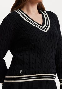 Μαύρο πλεκτό πουλόβερ με καλώδιο, σχέδιο v-neck και ριγέ γιακά. Διαθέτει αντίθετη ριγέ στρίφωμα και κεντημένο λογότυπο ως διακόσμηση.