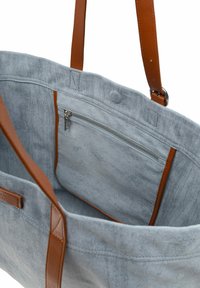 Siva zamudna torba z rjavimi usnjenimi ročaji in zadrgo na notranjem žepu. Notranjost ima mehkobo in gladek zaključek.