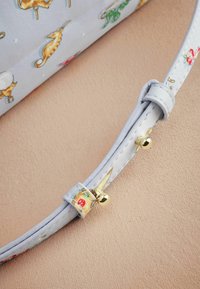 Ljusblå handväska rem med texturerad yta, prydd med guldiga detaljer och ett lekfullt mönster av sjöhästar och marint liv.