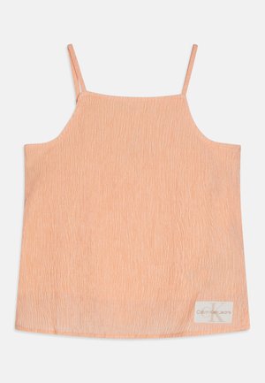 Canotta color pesca con spalline sottili, design strutturato che ricorda strisce verticali e piccola etichetta con il logo Calvin Klein Jeans.