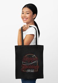 Borsa tote nera con manici lunghi, con la scritta "Felice Natale" in corsivo rosso e stelle bianche, arricchita con il logo Coca-Cola in basso.