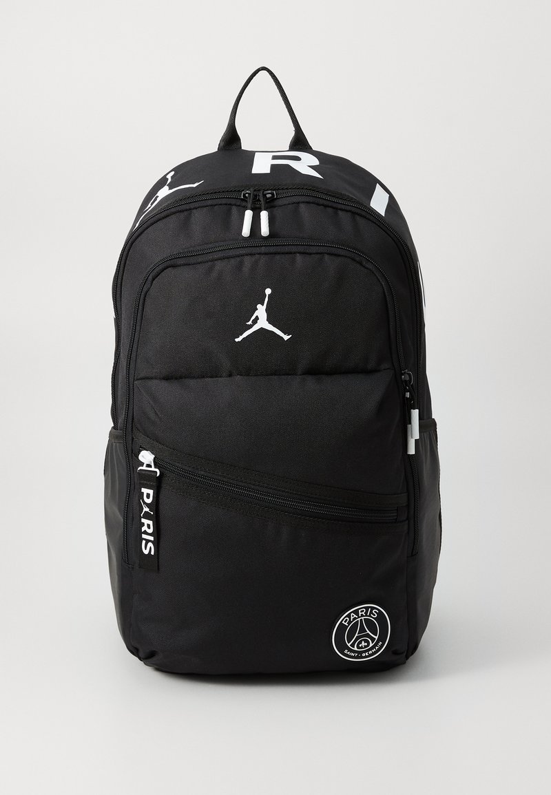 Juodas kuprinė su tekstūruota medžiaga, pasižyminti dideliu baltu Jumpman logotipu ir tekstu "PARIS" ant užtrauktuko. Turėtų vieną priekinį kišenę.