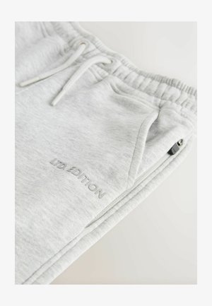 Svetlo sivi trenirka iz mehkega blaga, z elastičnim pasom, vrvico, stranskimi žepi in vezenjem "LTD EDITION".